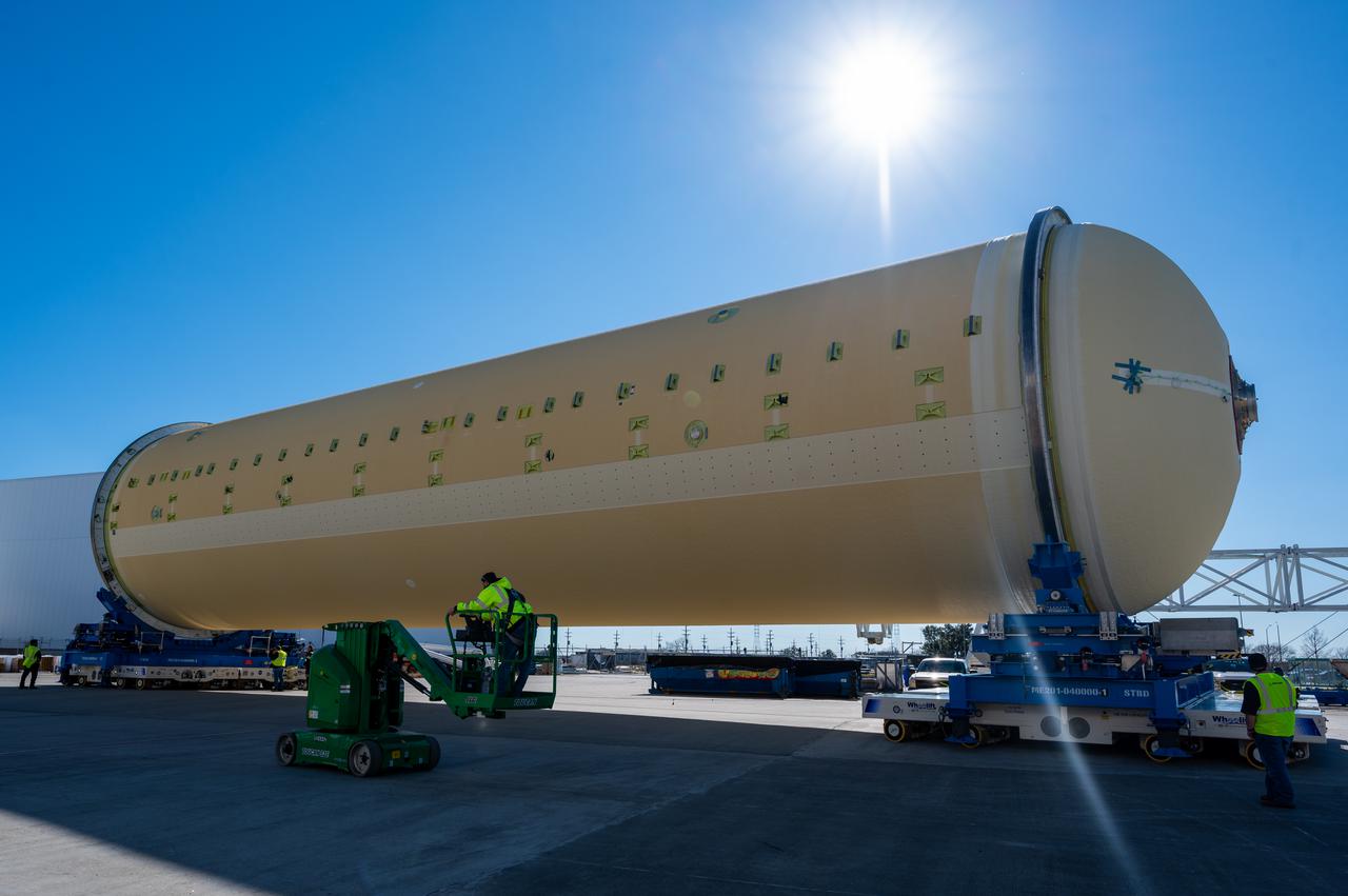 Technicians transported the assembled upper part of the Artemis II core stage to the final assembly area inside the factory at NASA’s Michoud Assembly Facility in New Orleans.  On Jan 10, the forward assembly, left was moved next to the Artemis II liquid hydrogen tank, which has been undergoing assembly. Next, Boeing, the lead core stage contractor, will join the forward assembly and the liquid hydrogen tank to complete most of the core stage for the Space Launch System (SLS) rocket that will send the first crew on an Artemis mission. The core stage consists of five major structures that are built, outfitted, and then connected to form the final stage. The forward skirt, liquid oxygen and intertank were connected and tested to form the 66-foot forward assembly. After the forward assembly is joined with the 130-foot liquid hydrogen tank, only the engine section, the fifth piece of the stage, will need to be added to complete the Artemis II core stage.  The core stage serves as the backbone of the rocket, supporting the weight of the payload, upper stage, and crew vehicle, as well as the thrust of its four RS-25 engines and two five-segment solid rocket boosters attached to the engine and intertank sections. On Artemis II, the SLS rocket will launch the Orion spacecraft and a crew, sending them into lunar orbit, in preparation for later Artemis missions that will enable the first woman and first person of color to land on the Moon.